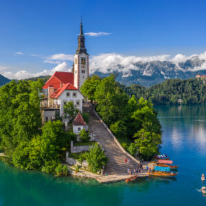 Bled, Slovenia - Aerial drone view of beautiful Lake Bled (Blejsko Jezero) with the Pilgrimage Church of the Assumption of Maria and Bled Castle and Julian Alps at backgroud on a bright summer day